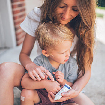 Mom applying recovery cream on child