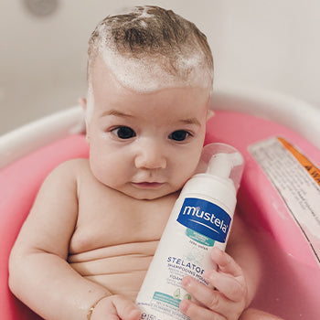 baby having a bath with Mustela products