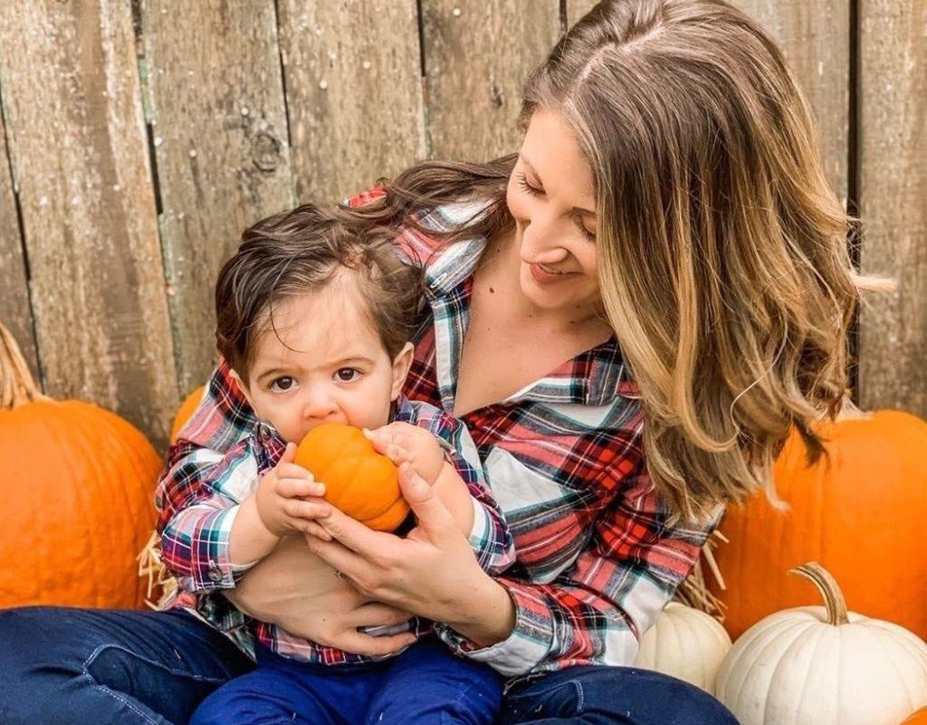 Mom taking pumpkin patch pictures with son