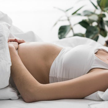 woman laying on her back during her first trimester