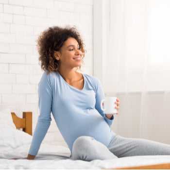 pregnant woman drinking from a mug 