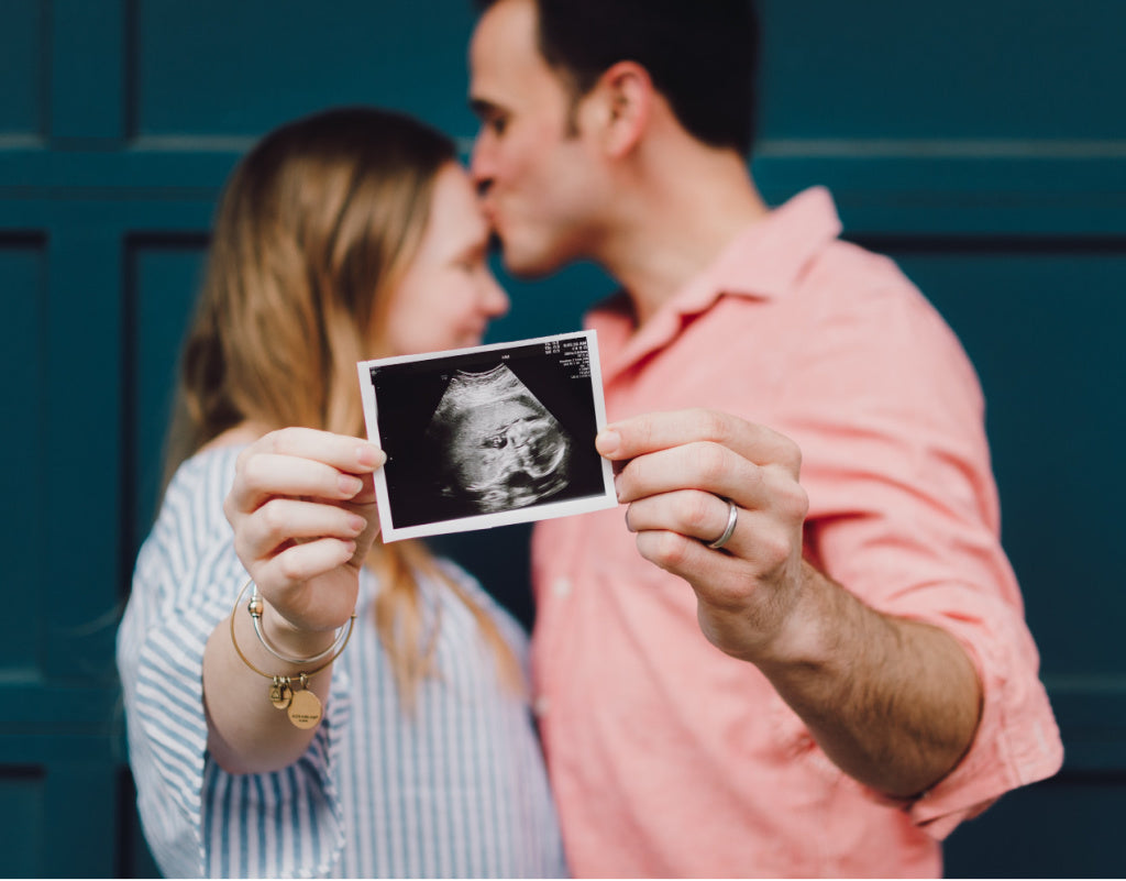 Couple holding sonogram picture of baby
