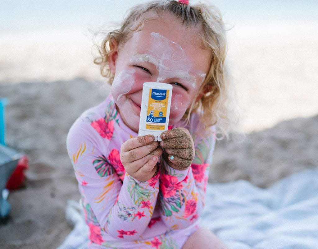 Young girl learning how much sunscreen to use on face