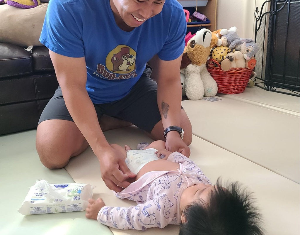  Dad learning how should a diaper fit on a baby