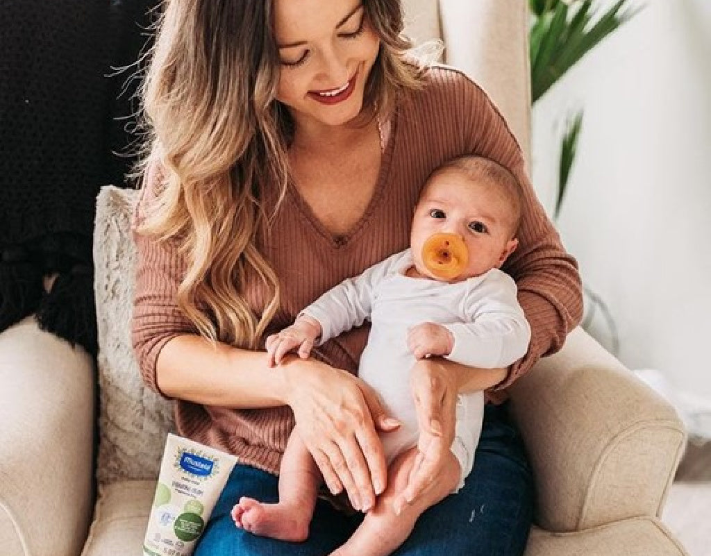 Mom holding her baby after learning how to calm a fussy baby