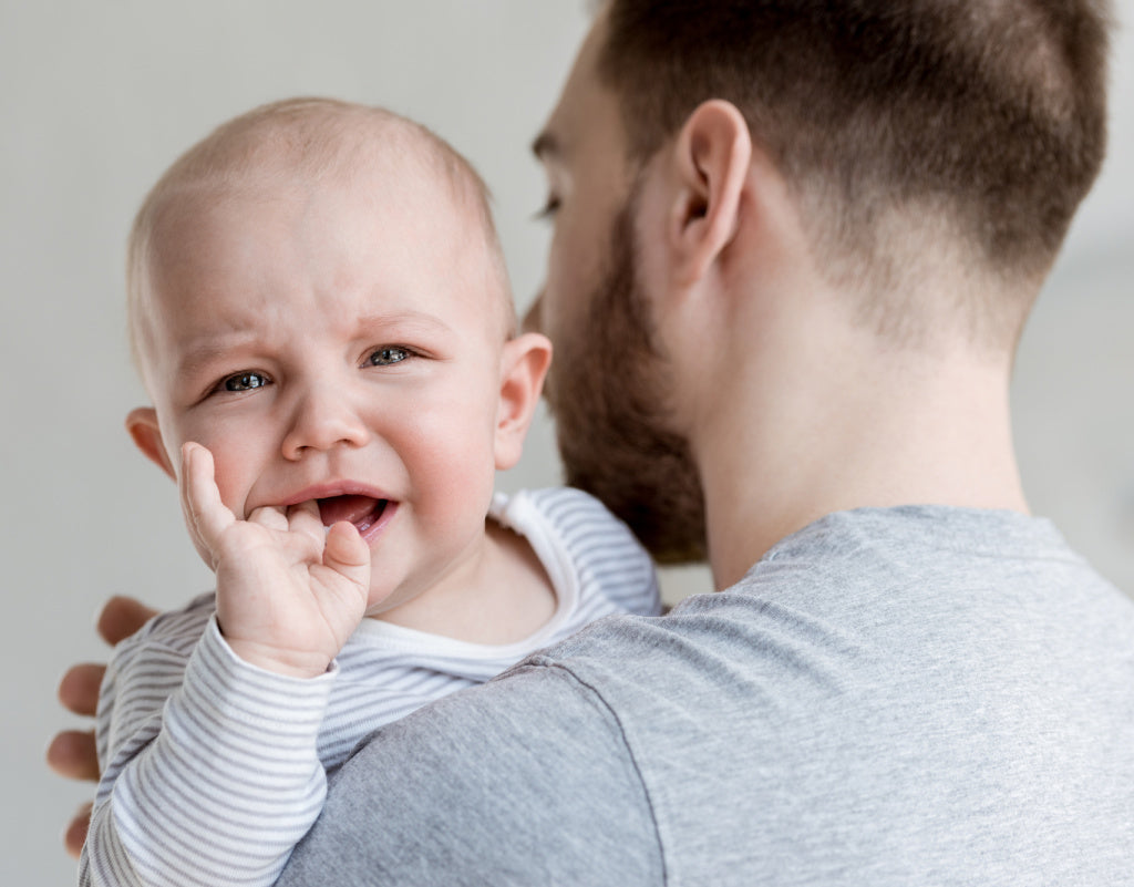 Dad holding baby while learning how to calm a fussy baby