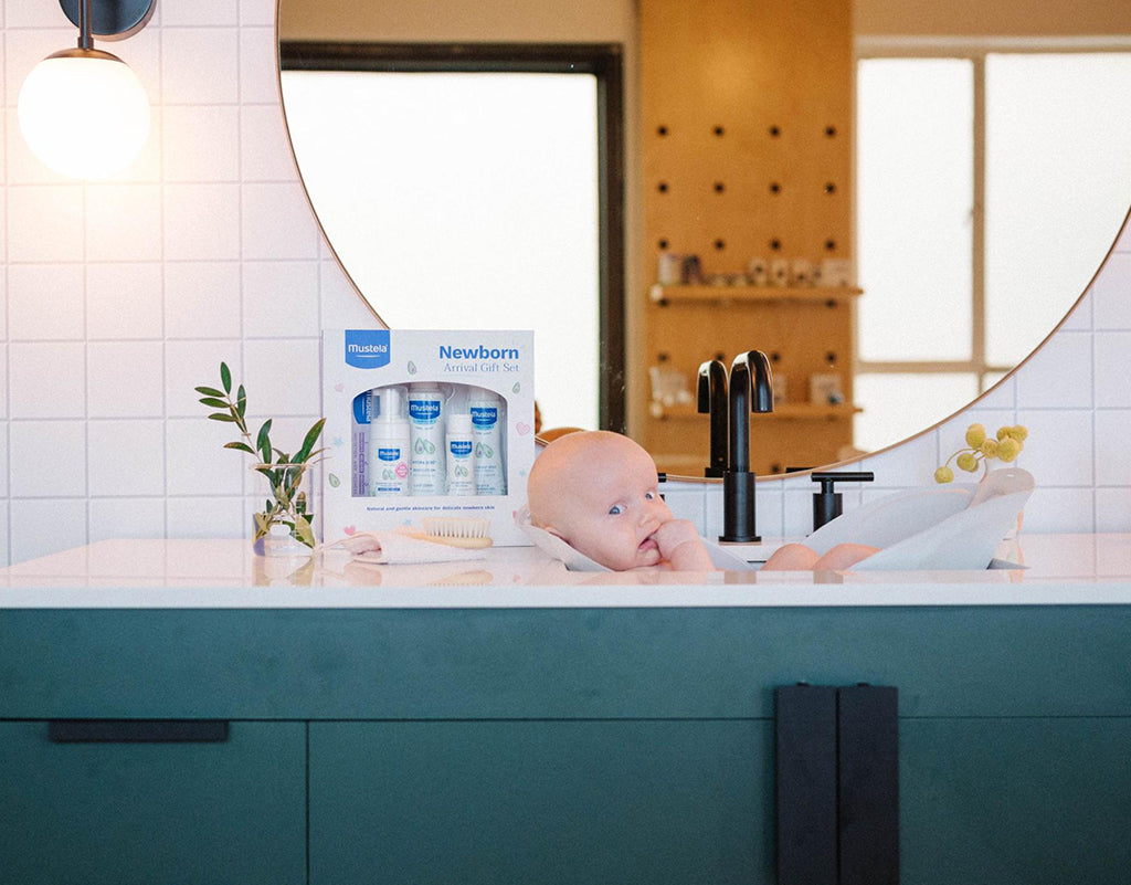 Baby during bath time while parents learn how to clean baby ears