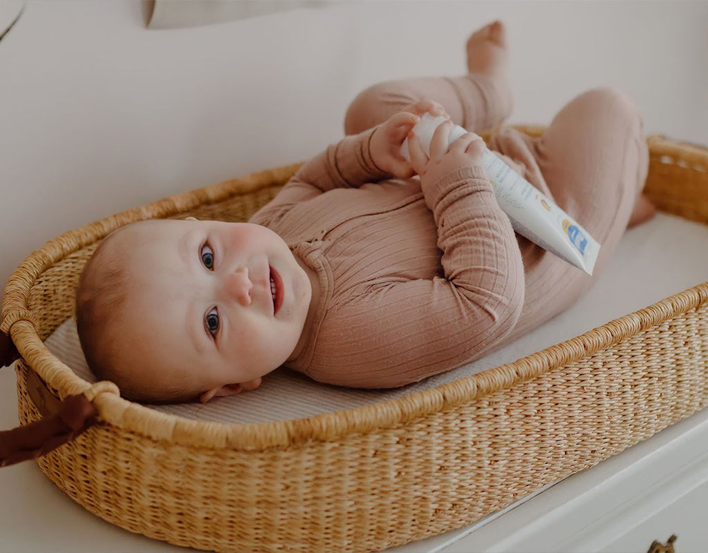 Baby laying in changing bassinet