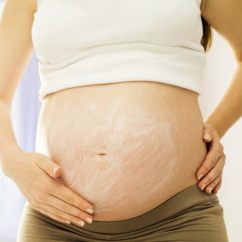 pregnant woman applying Stretch Marks Cream to belly