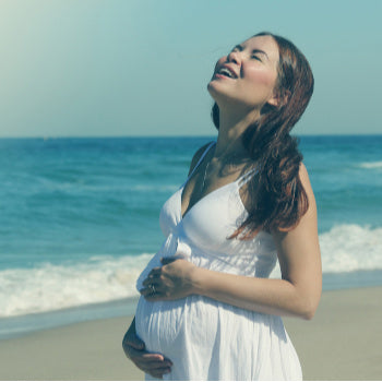 Pregnant woman protecting her stomach from the sun to prevent linea nigra