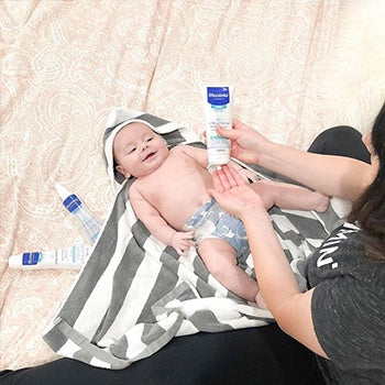 Mom applying cream on baby 