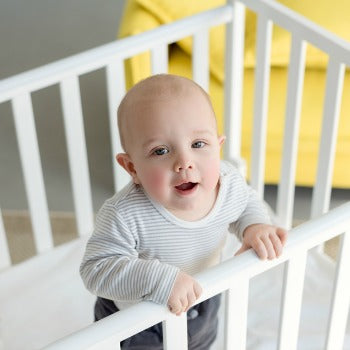 Baby standing in a crib