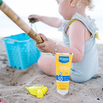 Young girl at the beach with Mustela sunscreen