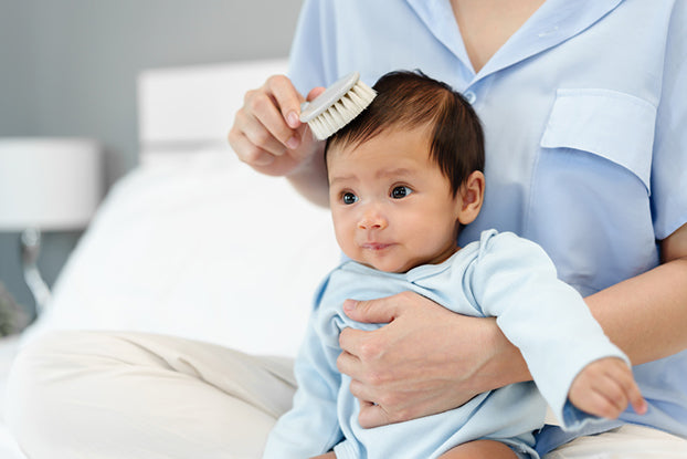 Parent brushing newborn hair