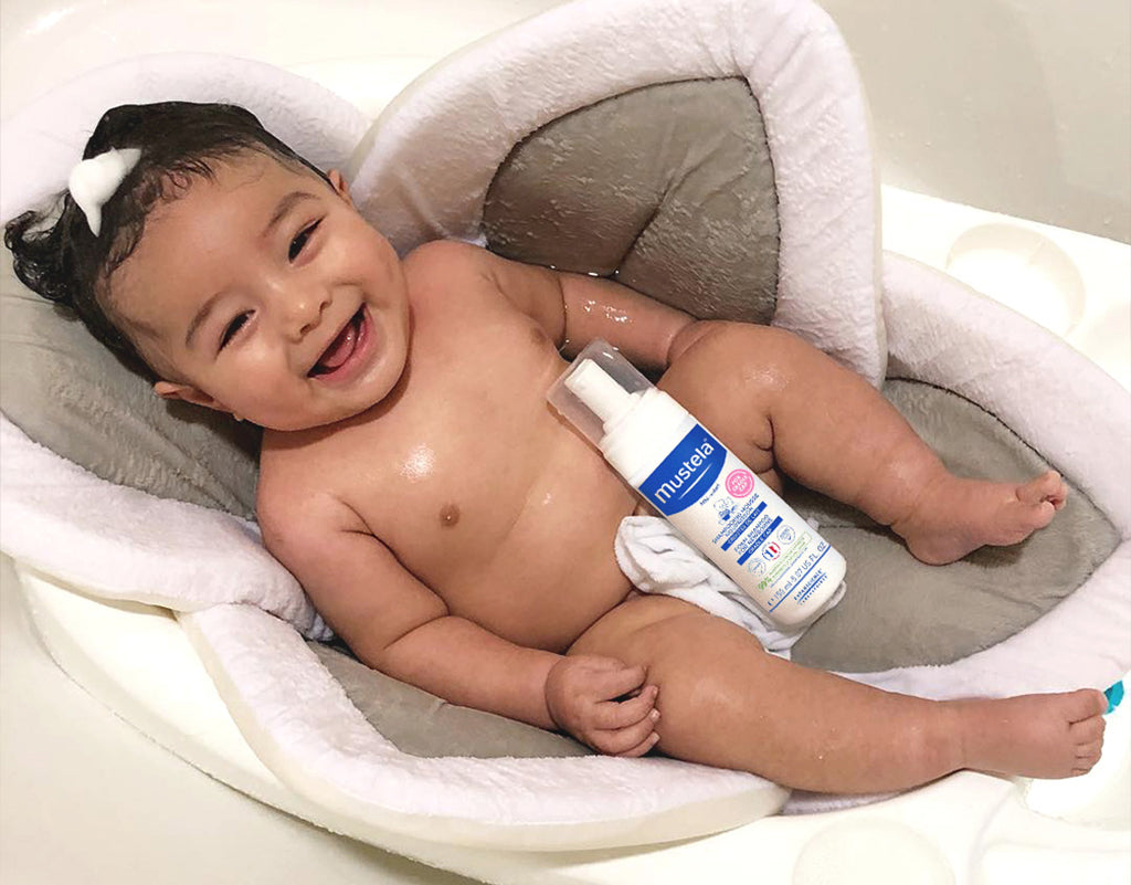 Baby getting a bath with Mustela’s Foam Shampoo for Newborns