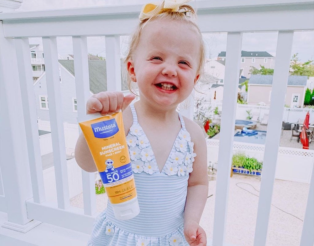 Young girl holding SPF 50 Mineral Sunscreen Lotion