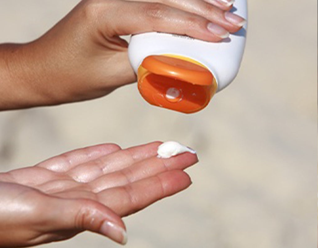 Woman pouring sunscreen on hand