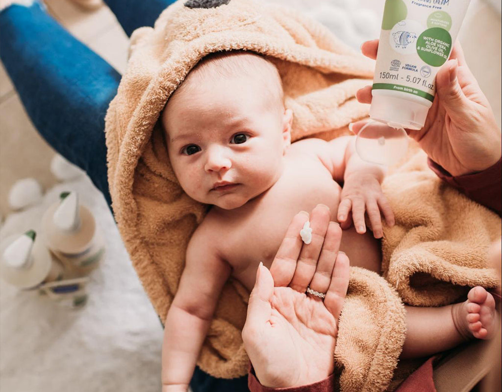 Mom applying lotion with olive oil for skin on baby