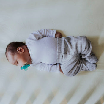 baby sleeping while sucking on pacifier