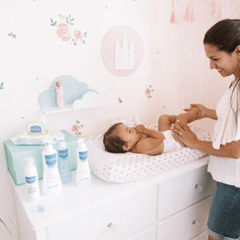 Mom changing baby diaper with paraben free products