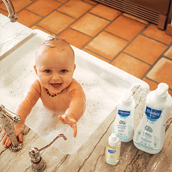 Baby taking a bath in the kitchen sink