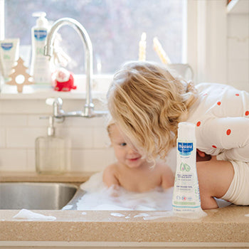 Sister helping bath younger sibling