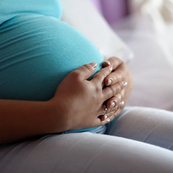 Pregnant women sitting and holding belly