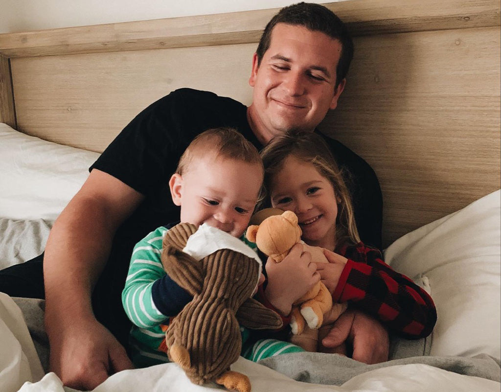 Dad with kids in bed with stuffed animals