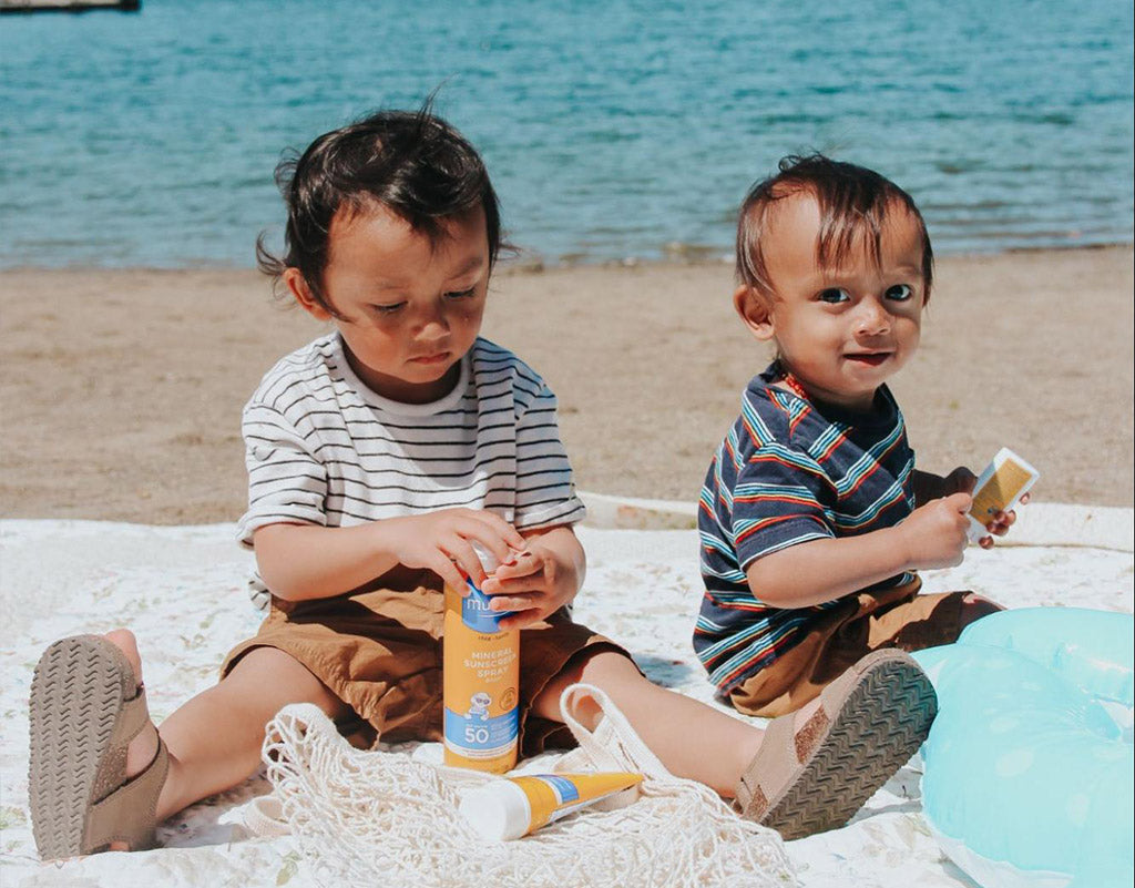 Two kids at the beach protected by Mustela Sun Products