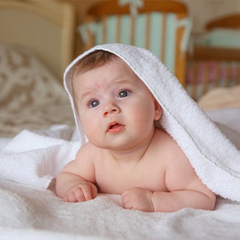 baby laying under a towel