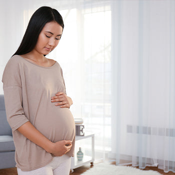 Woman holding her stomach during her second trimester