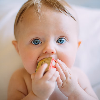 baby teething on a block