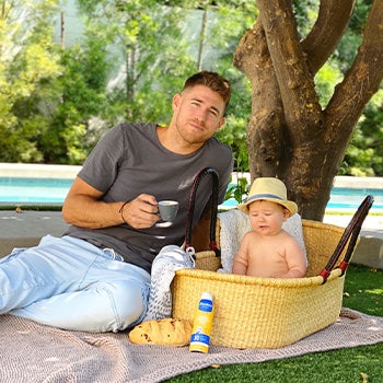 Dad on picnic with child and prepared with spray sunscreen