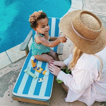 Mom applying sunscreen for eczema to child while at the pool