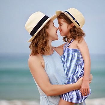 mom holding daughter whose wearing sunscreen for eczema