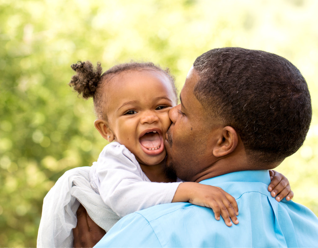 Dad kissing teething baby