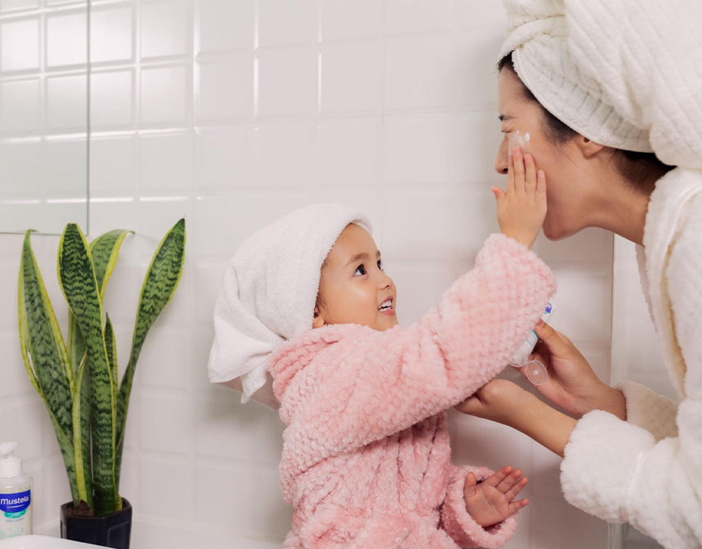 Daughter applying moisturizer on moms face