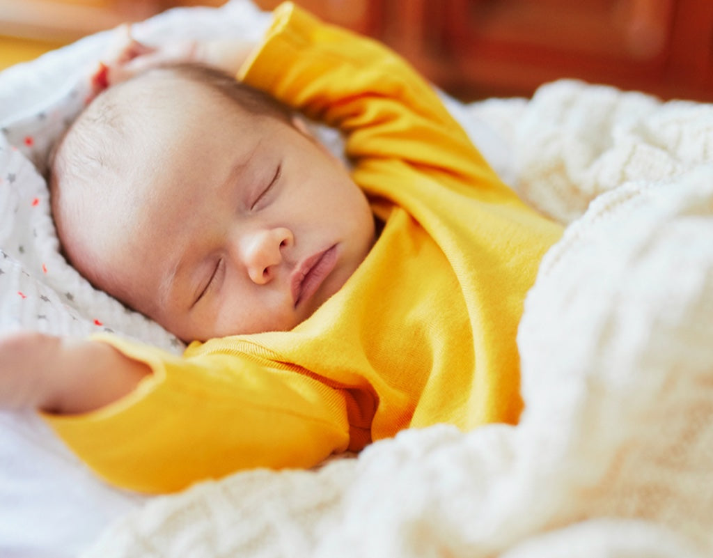 Baby laying on back with arms up