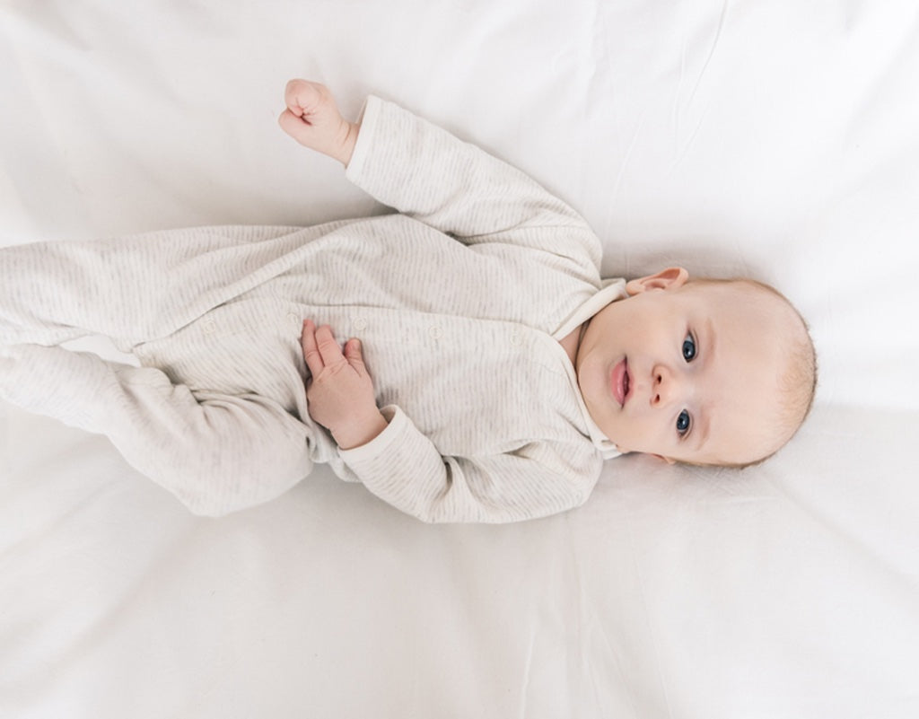 Parent checking on baby wondering when can baby sleep with blanket