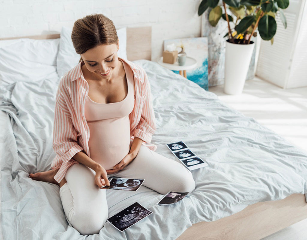 Pregnant woman looking at sonograms and deciding when to have a baby shower