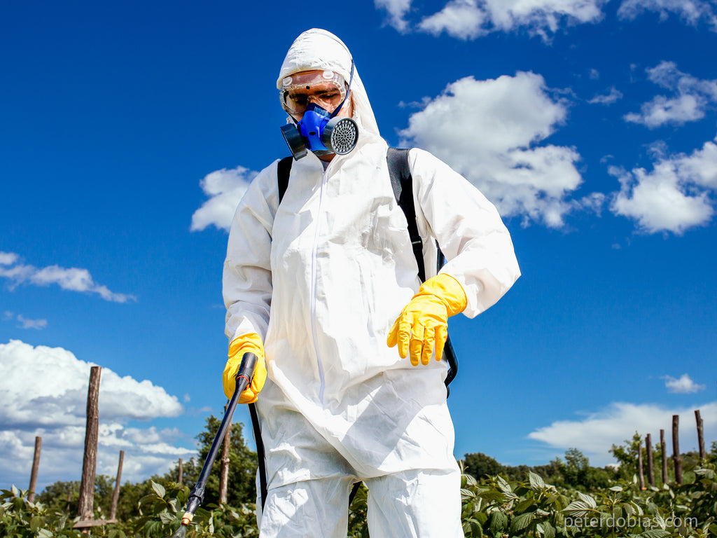 Man in hazard suit spraying chemicals