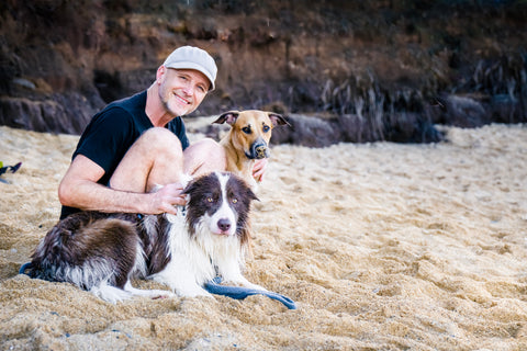 Dr. Dobias with dogs Pax and Lana on the beach