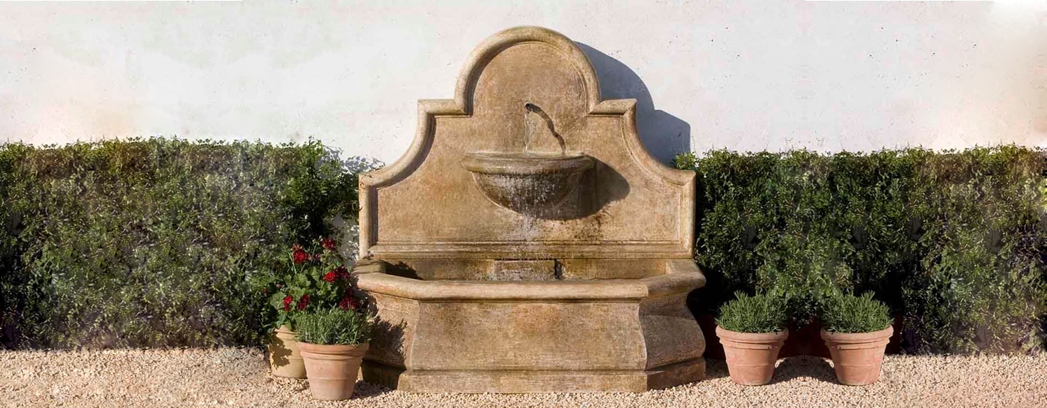 Andalusia Fountain on gravel against light gray wall