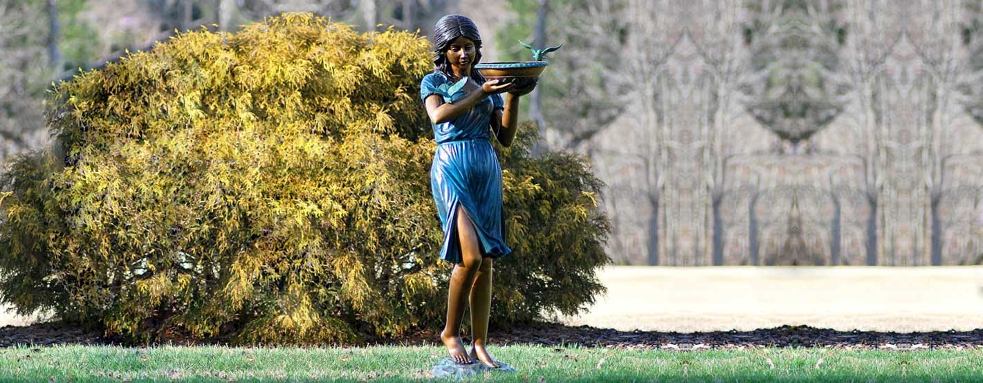 Bronze Girl with birdbath fountain sculpture on grass in the backyard