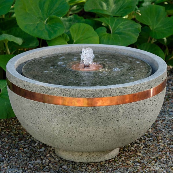 Campania International El Sol Copper Banded Fountain on concrete in the backyard