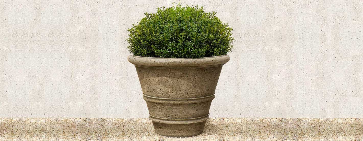Rustic Rolled Rim 40 Planter on gravel in the backyard