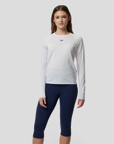 Woman in white long sleeve gym t shirt and navy leggings