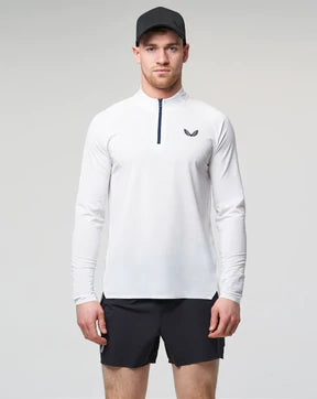 white Castore running 1/4 zip top with black shorts and cap