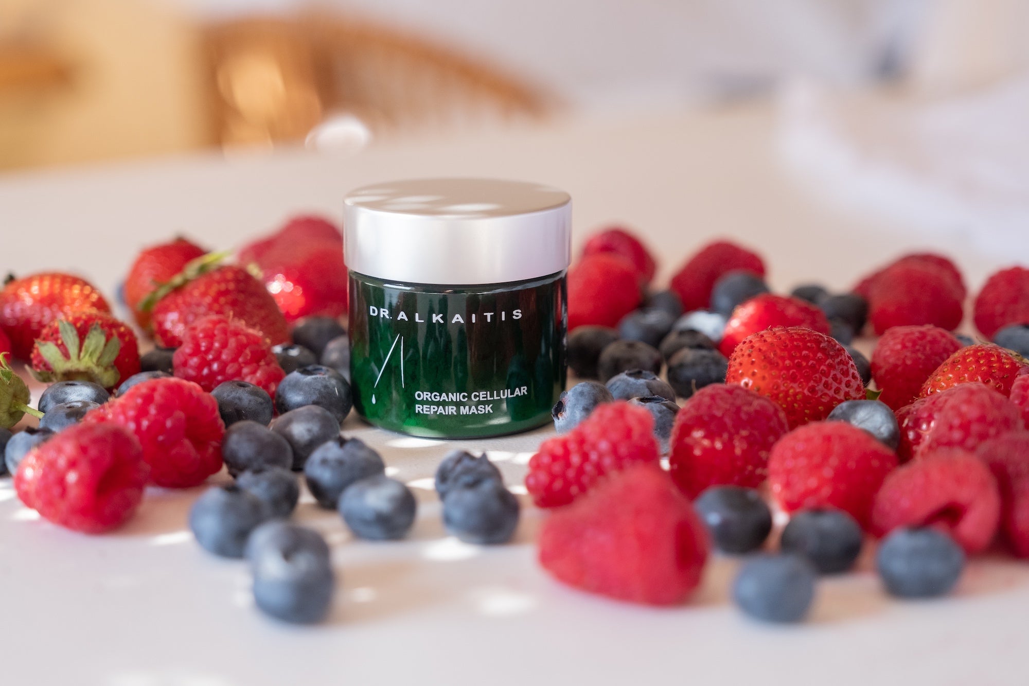 Jar of Dr Alkaitis Organic Cellular Repair Mask surrounded by blueberries, strawberries and raspberries