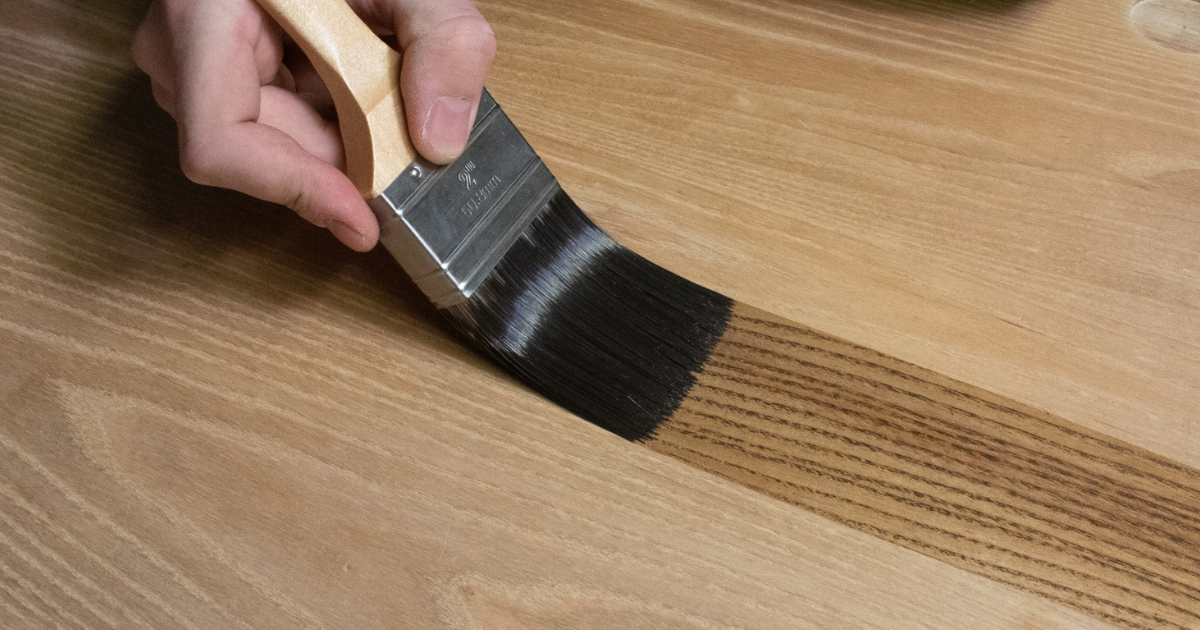 applying wood stain with a brush